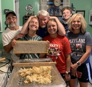 Group of young beekeepers and mentors with a frame of capped honey